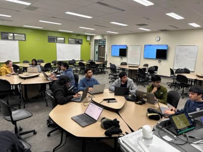 people sitting on round tables in a classroom facing to the bottom right