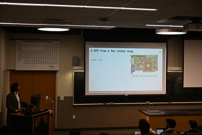classroom front with projector showing slide titled 'a gpu from a few inches away' bullet point 'not a cpu'